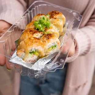 a person holding a container of food