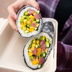 a person holding a tray of sushi