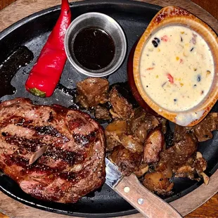 Bone-In Ribeye with skillet potatoes and creamed corn.