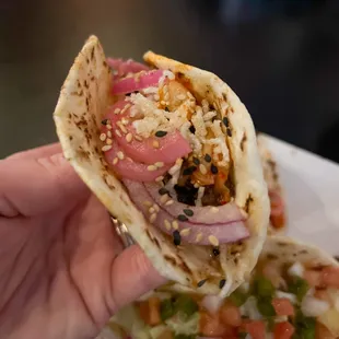 a hand holding a taco