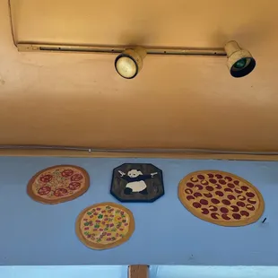 three pizzas on a blue wall