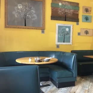 a corner booth with a table and chairs