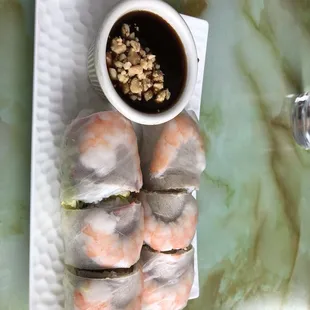 a plate of shrimp rolls with dipping sauce