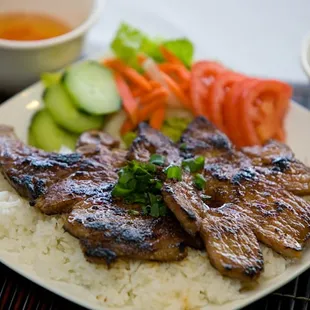 BBQ Pork Chops with White Jasmine Rice, Salad, Cucumbers, Tomatoes, Pickled Carrots and Daikong, served with Nuoc Mam and Pho Broth