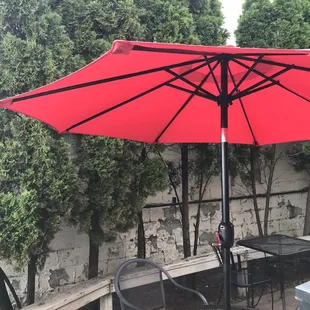 a patio with tables and chairs and an umbrella