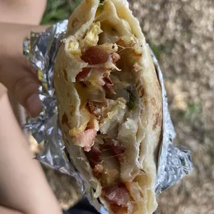 a hand holding a burrito