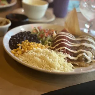 Tamales, one with chicken and salsa verde and one with beef with their red sauce.