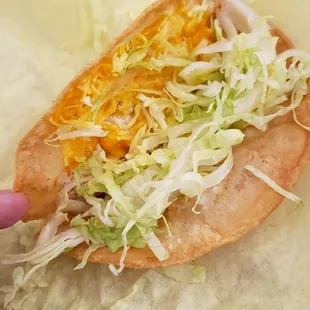 a hand holding a taco