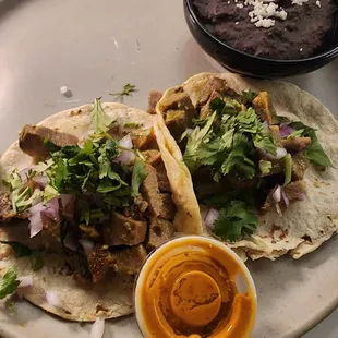 Lengua Tacos and refried black beans with house hot sauce