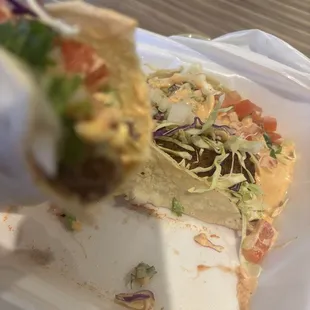 A big taco with one tortilla and the fish is burnt.