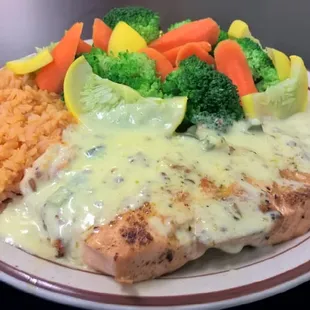 Salmon with a pecan sauce and steamed vegetables.