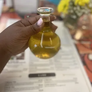a person holding a bottle of olive oil