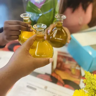 two people holding bottles of juice