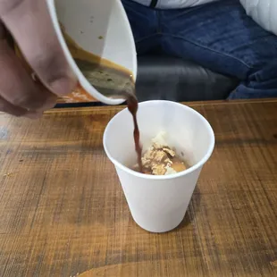 a person pouring coffee into a cup