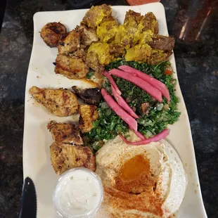 Chicken platter with hummus, tabouleh, and spicy potatoes