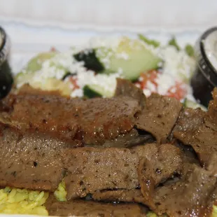 Lamb gyro plate served with lamb over rice and salad your choice of sauces