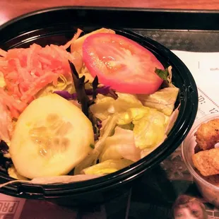 a bowl of salad and croutons