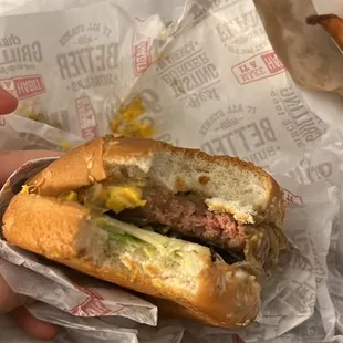 a hand holding a sandwich