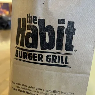 a paper bag with the habit burger grill logo