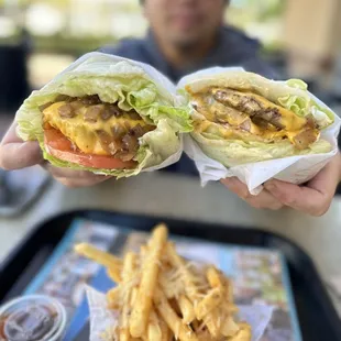 a man holding a sandwich and fries