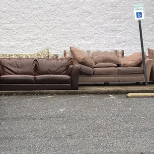 Several couches and chairs left outside uncovered in the rain. Would have taken larger frame picture but truck in the way.