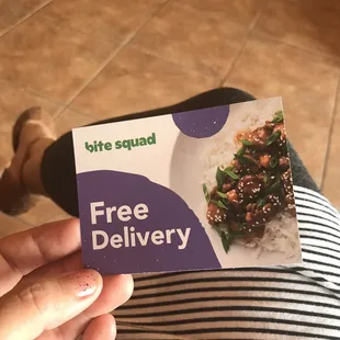 a person holding a free delivery card