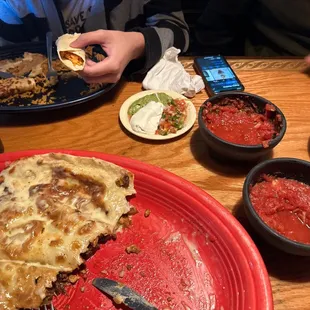 a plate of pizza and bowls of salsa