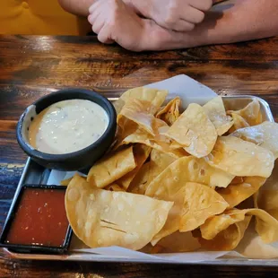 a plate of nachos and dipping sauce