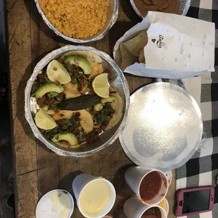 Mini tacos al pastor, refried beans, Mexican rice, queso and chips