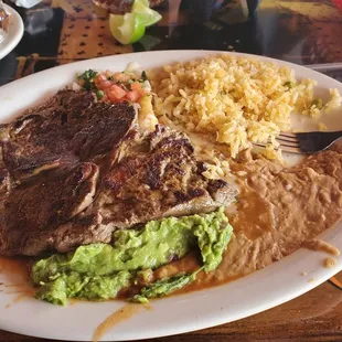 Carne Asada plate with rice and beans with one cheese enchilada.