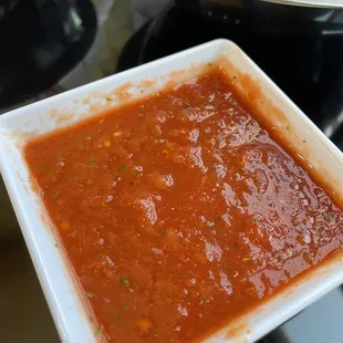 a square white plate of sauce