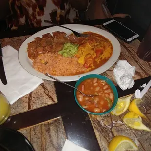 Carne Guisada plate with rice, refried beans, Charro beans and beef enchiladas