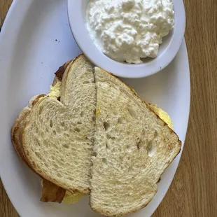 Breakfast sandwich with cottage cheese side.