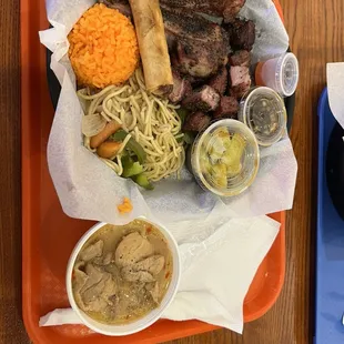 Lunch Plate 3 Choice with pork ribs, smoked pork pieces, and spicy chicken. Also rice, lumpia, noodles, and cucumber salad.