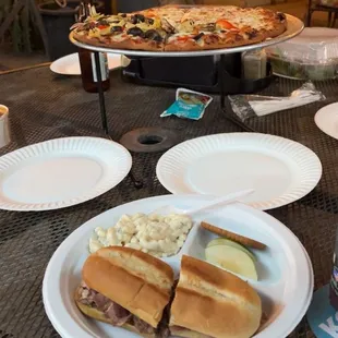 Tri tip sandwich with Mac salad. And a half and half pizza in the back.