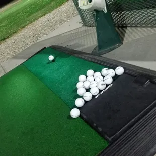 a golf putting mat with golf balls on it