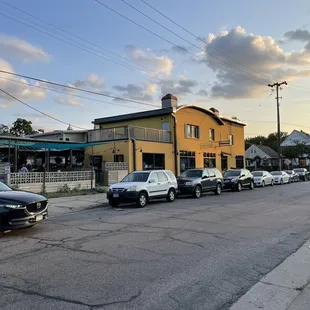 a row of parked cars in front of a yellow building