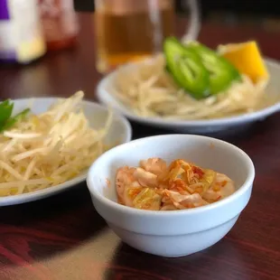 two bowls of noodles and a lemon wedge