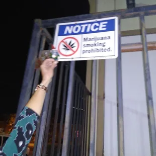 a woman holding a no smoking sign