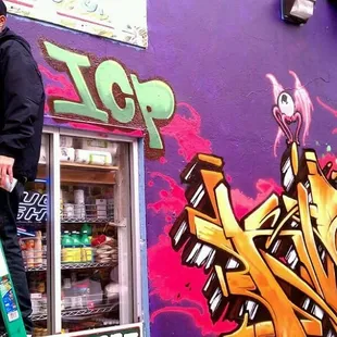 a man on a ladder painting a wall