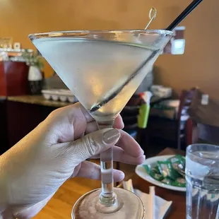 a hand holding a martini glass