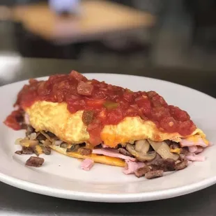 Omelette with sausage, cheddar cheese, onions, mushrooms, deli ham with salsa on top