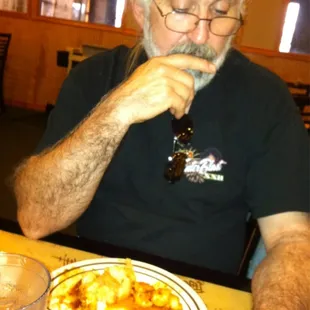 a man sitting at a table with a plate of food