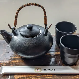 a teapot, two cups and a spoon