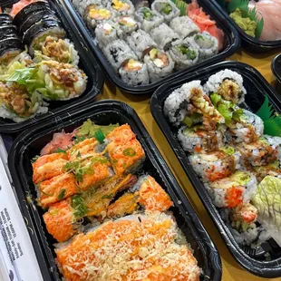 a variety of sushi in plastic containers