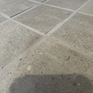 Uneven tiles and grout. Seams are messy and not sized correctly.