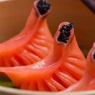 three pieces of sushi in a bowl with chopsticks