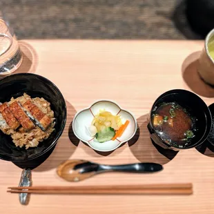 three bowls of food on a wooden tray