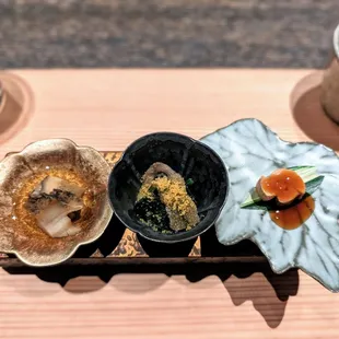 three bowls of food on a wooden tray