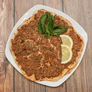 a pizza with a slice of lemon on top